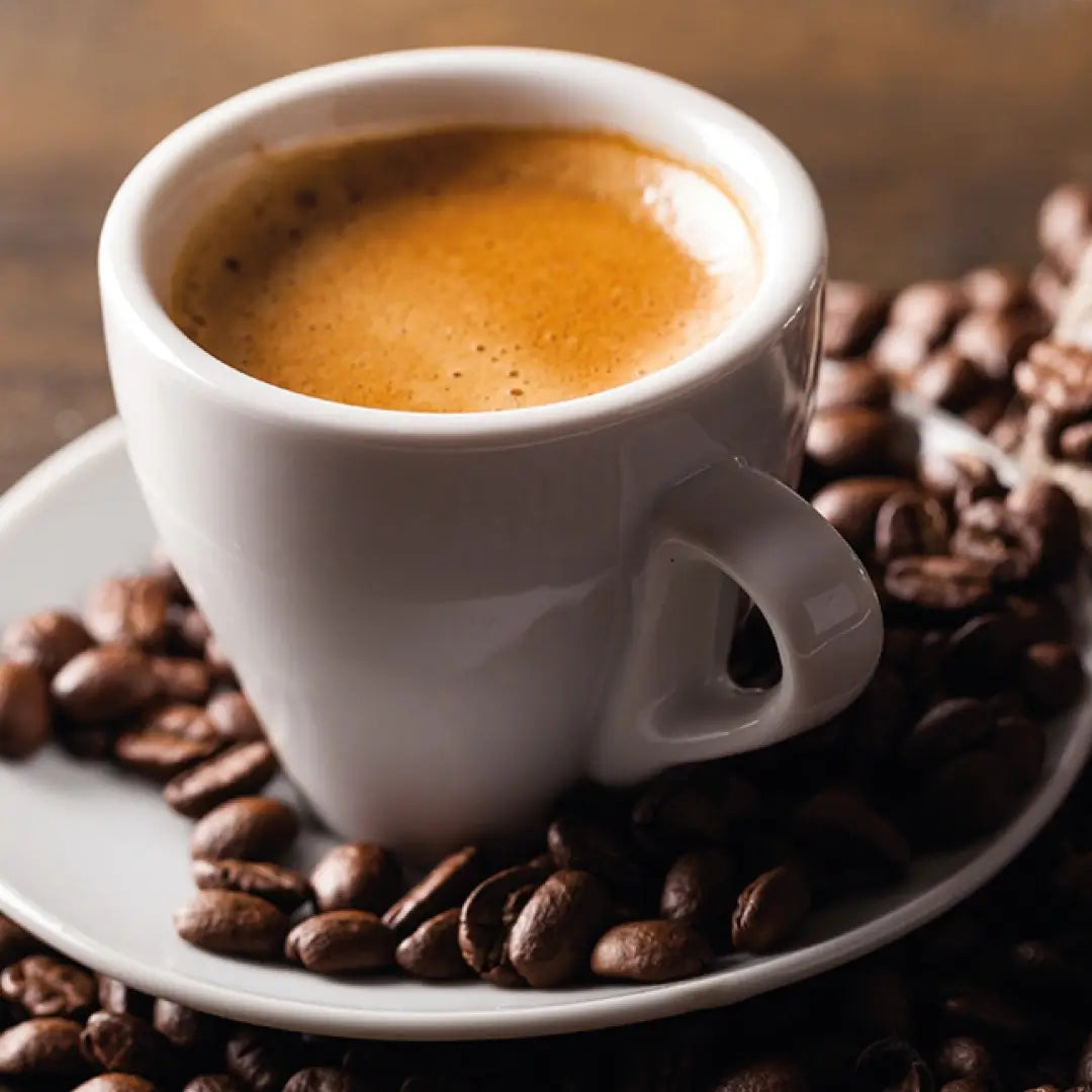 Tazzina di caffè su letto di chicchi di caffè